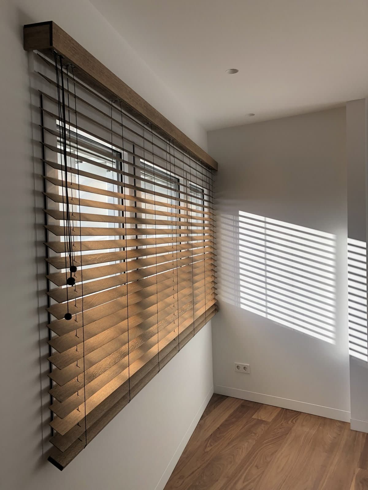 Window blinds filtering daylight into a room